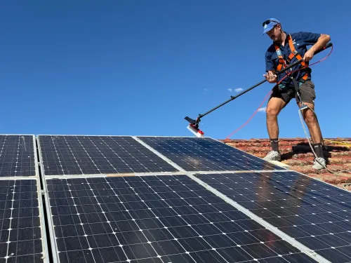 A dirty solar panel is being cleaned by Wattle Cleaning