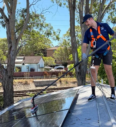 A Wattle Cleaning Technician Cleaning Solar Panels